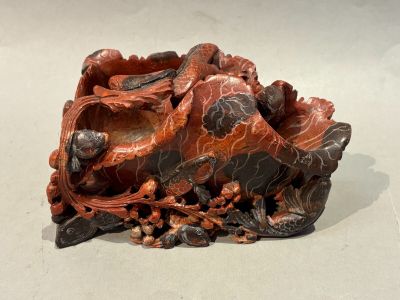 a sculpture of a fish on a rock on a white surface