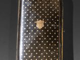 an antique gold cigarette case with stars on it on a black background