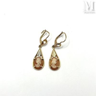 pair of gold tone earrings with mother and child ' s face on them