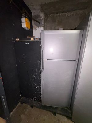 a refrigerator and a freezer in a dirty room