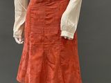 an image of a mannequin wearing a white blouse and orange skirt