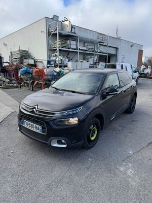 La voiture est garée sur le parking près de l'immeuble.