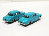 two toy cars sitting next to each other on a white surface
