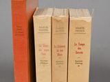 three books sitting on top of each other on a gray surface