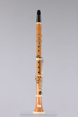 a close up of a wooden clarinet on a clear surface