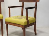two wooden chairs with yellow upholstered upholstered cushions