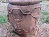 un grand pot contenant une plante, posé sur l'herbe