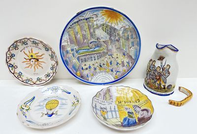 cinq assiettes et un vase posés sur une table