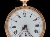 une montre de poche en or avec des chiffres romains