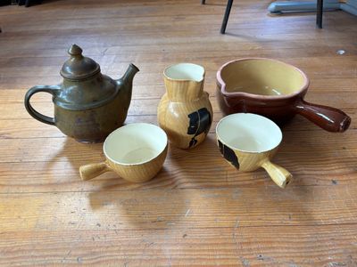 trois tasses et une théière posées sur une table en bois