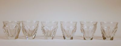 six verres sont alignés sur une surface blanche