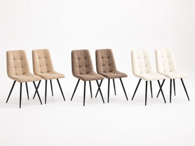 un ensemble de quatre chaises aux pieds noirs et aux assises rembourrées beiges
