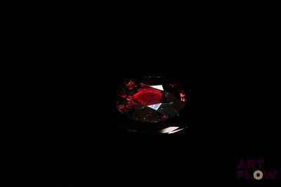 a close up of a red diamond in the dark