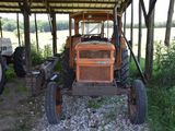 a tractor that is parked under a covered structure