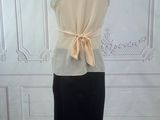 beige and black dress on a mannequin stand in a room
