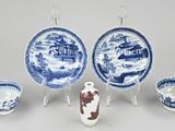 plusieurs assiettes et bols bleus et blancs, ainsi qu'un vase posé sur un socle