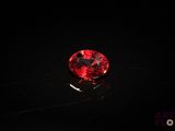 un diamant rouge sur une surface noire