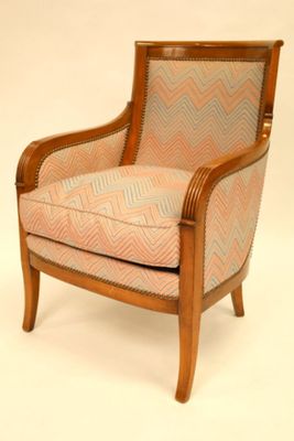 une image représentant une chaise en bois dont l'assise est rembourrée et ornée d'un motif