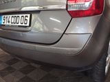 a silver car parked in a garage with a number plate on the back
