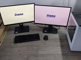 deux écrans d'ordinateur posés sur un bureau avec un clavier et une souris