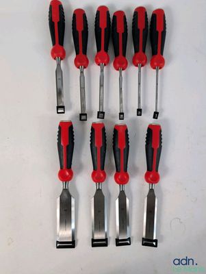 six outils rouges et noirs sont alignés sur une surface blanche