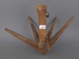 an old wooden bird with a tag on it ' s neck