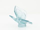 a glass sculpture of a bird on a white surface