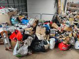 a large pile of garbage in a garage next to a garage door