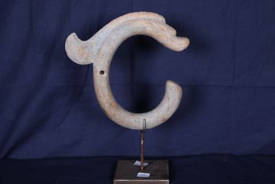 une photo d'une sculpture représentant la lettre « c » posée sur un socle en bois