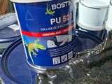a bucket of paint sitting on top of a table next to a cup