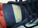 a person holding a pair of shoes with a label on it