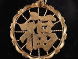 pendentif plaqué or orné de caractères chinois sur fond noir