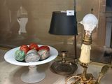 une table sur laquelle se trouvent une assiette de fraises et une lampe