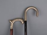 two old walking canes sitting next to each other on a gray surface