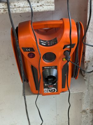 un souffleur orange posé sur un mur, près d'une fenêtre