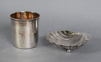 a silver cup and a silver plate on a table
