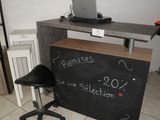 un tableau noir posé sur le comptoir, avec un ordinateur portable dessus