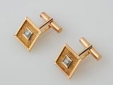 two pairs of gold and diamond cufflinks on a white surface