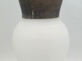 a white vase with a brown top sitting on a table