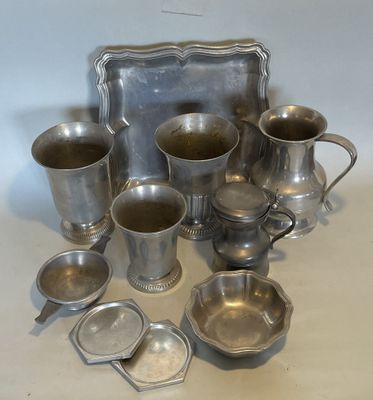 many silver cups and trays sitting on a table