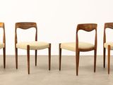 three wooden chairs with beige upholstered seats sit in a row
