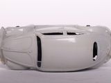 a white toy car that is sitting on a white surface