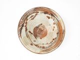a brown and white bowl sitting on a white surface