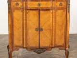 une armoire ancienne en bois avec un plateau en marbre, posée sur un parquet à lames en chevrons