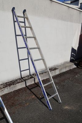 two ladders leaning against a wall next to a truck