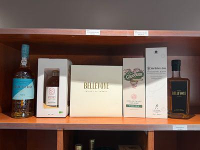 des bouteilles et des cartons d'alcool sur une étagère dans un magasin