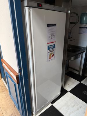 a white refrigerator in a kitchen with a black and white checkered floor