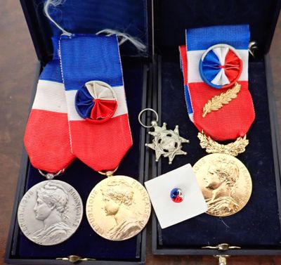 deux médailles et une médaille dans un écrin posé sur une table