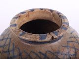 a brown vase with blue writing on it on a white surface