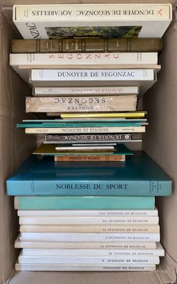 many books stacked in a box on top of each other